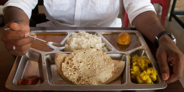 India, Mumbai, Man eating Indian food