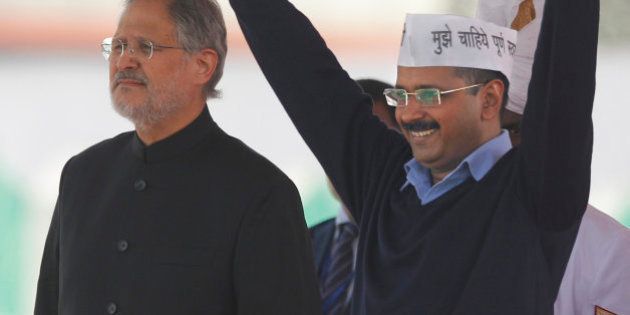 Aam Aadmi Party, or Common Man's Party, leader Arvind Kejriwal greets the crowd after taking oath as Chief Minister of Delhi, as Lieutenant Governor Najeeb Jung stands by his side in New Delhi, India, Saturday, Feb. 14, 2015. The AAP, headed by the former tax official who had remade himself into a champion for clean government, won 67 of the 70 seats in recent elections. Kejriwal and the party he created routed the country's best-funded and best-organized political machine and dealt an embarrassing blow to Prime Minister Narendra Modi. (AP Photo/Altaf Qadri)