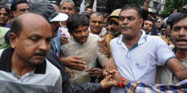 Hardik Patel, center, 22-year-old firebrand leader of Patidar Andolan Samiti walks after he was denied permission to hold a rally in Surat, India, Saturday, Sept. 19, 2015. Police in western Indian detained Patel, the wildly popular leader of a farming caste group Saturday. The Patidars, also known as the Patel community for the last name they share, are demanding they be granted the same special status given to many minorities in India, guaranteeing them a share of government jobs and school places. (AP Photo/Dinesh Trivedi)