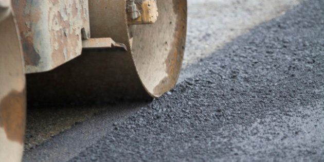 Industry Paving Machine rolling over fresh tar