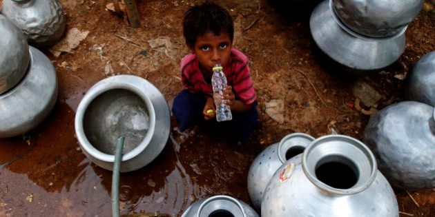 An Indian boy drinks water collected from a government water supply tap at an impoverished settlement on a hot summer day in Bhubaneswar, India, Saturday, May 30, 2015. Heat-related conditions, including dehydration and heat stroke, have killed more than 1,000 people in the southern Indian state of Andhra Pradesh and hundreds in Telangana since mid-April, according to state officials. (AP Photo/Biswaranjan Rout)