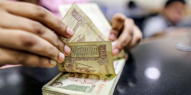 An employee counts Indian five-hundred rupee banknotes for a photograph at a branch of the HDFC Bank Ltd. in Mumbai, India on Thursday, Aug. 22, 2013. India's rupee slumped to an all-time low after Federal Reserve minutes showed the U.S. is getting closer to reducing stimulus that has fueled demand for emerging-market assets. Photographer: Dhiraj Singh/Bloomberg via Getty Images