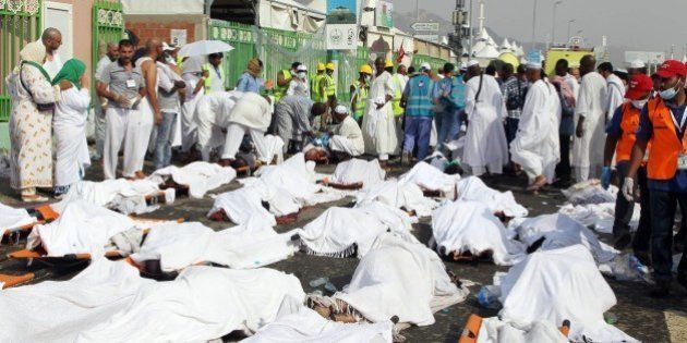 GRAPHIC CONTENT Saudi emergency personnel stand near bodies of Hajj pilgrims at the site where at least 717 were killed and hundreds wounded in a stampede in Mina, near the holy city of Mecca, at the annual hajj in Saudi Arabia on September 24, 2015. The stampede, the second deadly accident to strike the pilgrims this year, broke out during the symbolic stoning of the devil ritual, the Saudi civil defence service said. AFP PHOTO / STR (Photo credit should read STR/AFP/Getty Images)