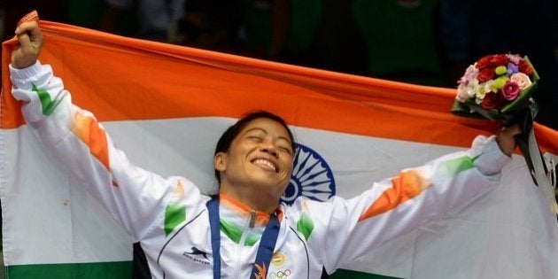 Gold medallist India's Hmangte Chungneijang Mary Kom celebrates during the victory ceremony after winning the women's flyweight (48-51kg) boxing final match against Kazakhstan's Shekerbekova Zhaina during the 2014 Asian Games at the Seonhak Gymnasium in Incheon on October 1, 2014. AFP PHOTO/ INDRANIL MUKHERJEE (Photo credit should read INDRANIL MUKHERJEE/AFP/Getty Images)