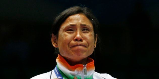 FILE - In this Oct. 1, 2014 file photo, India's L. Sarita Devi cries after she refused her bronze medal during the medal ceremony for the womenâs light 60-kilogram division boxing at the 17th Asian Games in Incheon, South Korea. The Indian female boxer who had refused to accept her bronze medal at the Asian Games has been banned for one year backdated to the day of the incident on Oct. 1, Boxing India said Wednesday, Dec. 17, 2014. Devi was angered by the judging in her semifinal loss in the 60-kilogram division and showed her displeasure in the medal ceremony, refusing to let the medal be placed around her neck. (AP Photo/Kin Cheung, File)