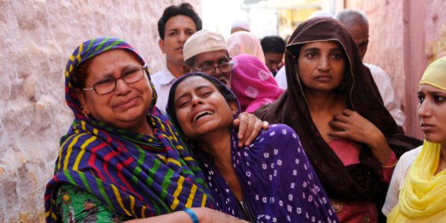 GREATER NOIDA, INDIA - SEPTEMBER 29: Family members of Mohammad Akhlaq (50-year-old man) mourn during his funeral at their village in Bisada on September 29, 2015 in Greater Noida, India. Akhlaq was beaten to death and his son critically injured by a mob over an allegation of storing and consuming beef at home, late night on Monday, in UPs Dadri. Police and PAC were immediately deployed in the village to maintain law and order. Six persons were arrested in connection with the killing of man. (Photo by Burhaan Kinu/Hindustan Times via Getty Images)