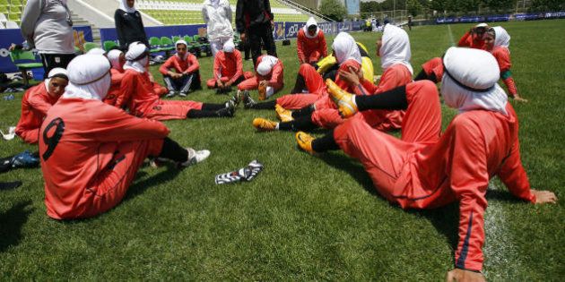 Players of Iran's women national football team listen to instructions before their friendly football match with club Malavan Anzali women's team in Tehran on June 25, 2009. The head of Iran's football federation has denied punishing players for wearing green wristbands in a show of support of the opposition during a World Cup qualifier, local media reported. AFP PHOTO/ISNA/AMIR POORMAND (Photo credit should read Amir Poormand/AFP/Getty Images)