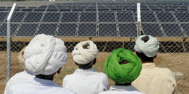 Indian villagers look at solar panels during the inauguration of a solar farm in the village of Gunthawada, Banaskantha district, some 175kms. from Ahmedabad on October 14, 2011. Chief Minister of the western Indian state of Gujarat Narendra Modi inaugrated the 30MW solar farm - said to be Asia's largest - which has been set up by Moser Baer Clean Energy. AFP PHOTO/Sam PANTHAKY (Photo credit should read SAM PANTHAKY/AFP/Getty Images)