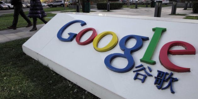 Pedestrians walk past the Google Inc. logo displayed outside the building housing the company's China headquarters in Beijing, China, on Monday, Nov. 12, 2012. Google Inc. reported higher traffic patterns on its sites in China after the company earlier said there was an unusual decline in the country, and an Internet monitor said company services were blocked there. Photographer: Tomohiro Ohsumi/Bloomberg via Getty Images