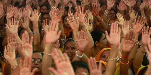 Members of Jain community raise their hands as they shout slogans during a protest in Mumbai, India, Monday, Aug. 24, 2015. The protest was against the recent Rajasthan High Court order of banning the religious practice of Santhara, a practice of fasting unto death. (AP Photo/Rafiq Maqbool)