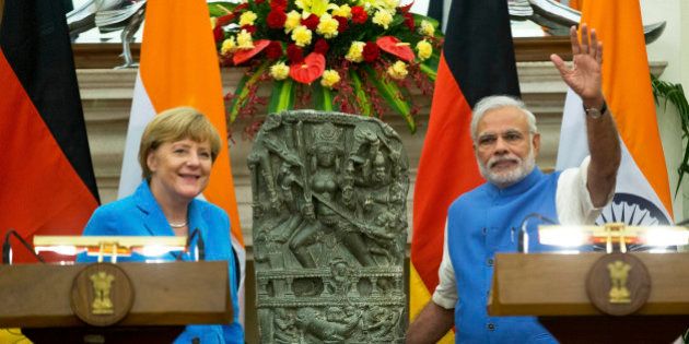 German Chancellor, Angela Merkel, left, and Indian Prime Minister Narendra Modi pose for a photograph with a 10th centery idol of Hindu Goddess Durga, that was returned by Germany, in New Delhi, India, Monday, Oct. 5, 2015. Merkel is on a three-day visit to India. (AP Photo/Saurabh Das)