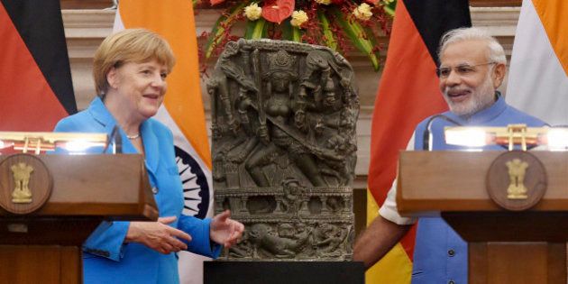 German Chancellor Angela Merkel, left and Indian Prime Minister Narendra Modi, pose with a tenth century idol of Hindu goddess Durga, that was returned by Germany in New Delhi, India, Monday, Oct. 5, 2015. Merkel is on a three-days official visit to India. (Atul Yadav/ Press Trust of India via AP) INDIA OUT
