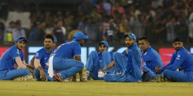 India's captain Mahendra Singh Dhoni (2R) sits with teammates as play is interrupted by spectators throwing bottles onto the pitch during the second T20 cricket match between India and South Africa at The Barabati Stadium in Cuttack on October 5, 2015. AFP PHOTO / DIBYANGSHU SARKAR --IMAGE RESTRICTED TO EDITORIAL USE - STRICTLY NO COMMERCIAL USE-- (Photo credit should read DIBYANGSHU SARKAR/AFP/Getty Images)