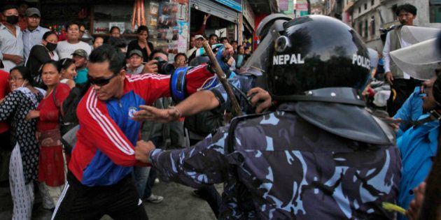 Nepalese protesters try to clash with policemen after burning a copy of the new constitution during the protest organized by splinter of the Maoist party, alliance of ethnic group and Madhesi party, in Kathmandu, Nepal, Monday, Sept. 21,2015. Nepal on Sunday, Sept. 20, 2015, formally adopted a much anticipated and long-delayed constitution that took more than seven years to complete following a decade of political infighting. However, security was stepped up across the nation, with smaller political parties and ethnic groups opposing to the new charter and fighting for equal representation in the countryâs political structure, which according to them has failed to meet their aspirations. (AP Photo/Niranjan Shrestha)