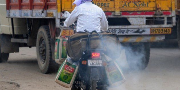 In this photograph taken on February 25, 2015, an Indian motorcyclist rides with smoke belching from his machine in New Delhi, ahead of World Environment Day which falls on June 5. The Indian government is under intense pressure to act after the World Health Organization last year declared New Delhi the world's most polluted capital. At least 3,000 people die prematurely every year in the city because of air pollution, according to a joint study by Boston-based Health Effects Institute and Delhi's Energy Resources Institute. AFP PHOTO/ MONEY SHARMA (Photo credit should read MONEY SHARMA/AFP/Getty Images)