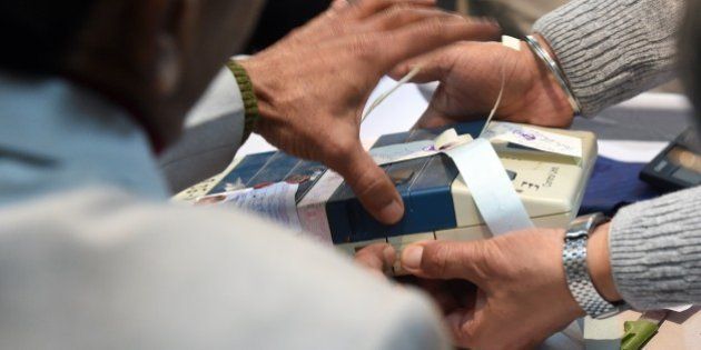 Indian election officials open a Electronic Voting Machine (EVM) at a vote counting centre in New Delhi on February 10, 2015. Counting of votes started for Delhi state elections, with exit polls indicating former chief minister Arvind Kejriwal's anti-corruption party has comfortably beaten Prime Minister Narendra Modi's Hindu nationalists. AFP PHOTO/ PRAKASH SINGH (Photo credit should read PRAKASH SINGH/AFP/Getty Images)