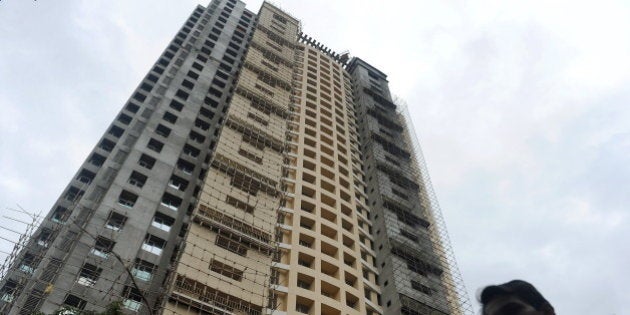 A local resident walks past the controversial Adarsh Housing Society apartments in Mumbai on November 9, 2010. The chief minister of Maharashtra, Ashok Chavan, one of India's richest states, was forced to resign on November 9 over his alleged role in a housing scam involving apartments meant for war widows. AFP PHOTO/ Punit PARANJPE (Photo credit should read PUNIT PARANJPE/AFP/Getty Images)