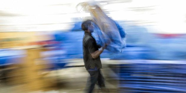 An employee carries a bag during the overnight sort at the Blue Dart Express Ltd. and DHL Express India Pvt. joint hub in Cargo Terminal 3 at Bengaluru International Airport in Bengaluru, India, on Saturday, Feb. 21, 2015. Blue Dart, a unit of DHL Express, is adding a Boeing Co. 757 freighter to its fleet of five in the South Asian country and building warehouses for sellers using portals such as Amazon.com Inc. and Flipkart.com, Malcolm Monteiro, chief executive officer of DHL eCommerce, said in an interview in Mumbai. Photographer: Dhiraj Singh/Bloomberg via Getty Images
