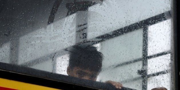 An Indian child looks out from his school bus in Faridabad on the outskirts of New Delhi on July 9, 2015, during heavy monsoon rainfall. AFP PHOTO/MONEY SHARMA (Photo credit should read MONEY SHARMA/AFP/Getty Images)