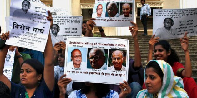 People hold placards during a protest against the killing of scholar M.M. Kalburgi in Mumbai, India, Tuesday, Sept. 1, 2015. Indian police are investigating the weekend murder of the scholar who was known for his outspoken criticism of idol worship and religious superstition. Placard on left reads,