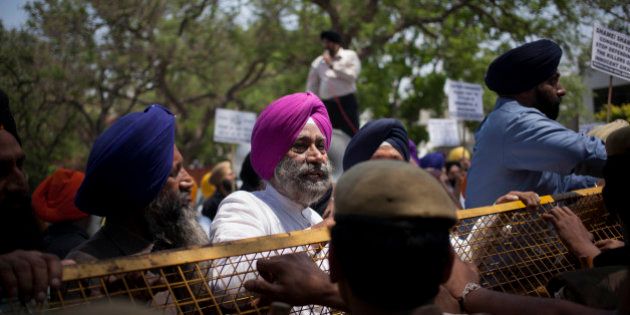 Indian Sikhs stand near a police barricade during a protest against Congress party leader and former chief minister of Punjab state Captain Amarinder Singh for his recent remarks on the countryâs 1984 anti-Sikh riots, in New Delhi, India, Monday, April 21, 2014. Singh in a recent television interview said party leader Jagdish Tytler, one of the accused, had no role in the 1984 riots that killed more than 3,000 Sikhs. Top Congress party leaders have been accused of inciting mobs during the violence that followed the assassination of Prime Minister Indira Gandhi by her Sikh bodyguards. (AP Photo/Tsering Topgyal)