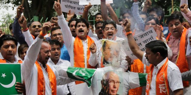 Hindu right-wing Shiv Sena activists burn an effigy and pictures of Pakistani Prime Minister Nawaz Sharif, top, and Pakistan's Prime Minister's Adviser on Foreign Affairs Sartaj Aziz during a protest in New Delhi, Saturday, Aug. 22, 2015. From left to right, the banners in Hindi read: