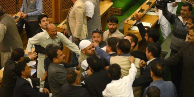 Independent lawmaker, Engineer Rashid (CL) shouts after being thrashed by Bhartiya Janta Party (BJP) legislators in the legislative assembly in Srinagar on October 8, 2015. Independent lawmaker Engineer Rashid, who was thrashed by BJP legislators, said he had not indulged in any illegal act by hosting a beef party at his official residence on the evening of October 7. AFP PHOTO/ Tauseef MUSTAFA (Photo credit should read TAUSEEF MUSTAFA/AFP/Getty Images)