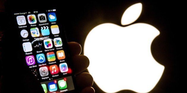 An illustration of an iPhone held up in front of the Apple Inc. logo taken of January 30, 2015 in Lille. AFP PHOTO / PHILIPPE HUGUEN (Photo credit should read PHILIPPE HUGUEN/AFP/Getty Images)