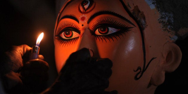 An Indian idol maker draws eyes onto a clay statue of Hindu goddess Durga, in Kumartoli, the idol makers village of Siliguri on September 29, 2011. Monsoon rain has made it difficult for artisans to finish idols on schedule and the recent economic slowdown and the high inflation is making the life difficult for these artist to do proper business ahead of this festive season. AFP PHOTO/Diptendu DUTTA (Photo credit should read DIPTENDU DUTTA/AFP/Getty Images)