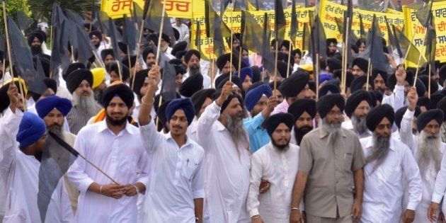 Activists from The Shiromani Gurdwara Parbandhak Committee (SGPC) hold black flags as take part in a protest in Amritsar on October 20, 2015, against the alleged desecration of a Guru Granth Sahib, the holy book of Sikhs. Sikhs are holding protests across Punjab over the alleged desecration of the Sikh holy book, The Guru Granth Sahib. AFP PHOTO/NARINDER NANU (Photo credit should read NARINDER NANU/AFP/Getty Images)