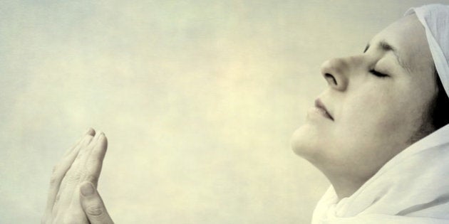 An Indian woman praying with folded hands.