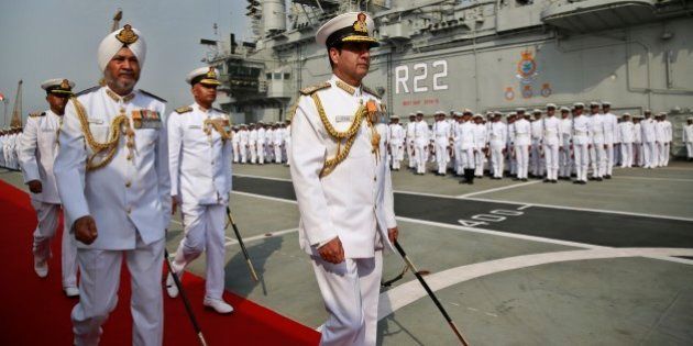 Indian Navy Chief Admiral R.K. Dhowan, center, along with chief of the Western Naval Command Vice Admiral S.P.S. Cheema, leave after participating in the Naval investiture ceremony held onboard the vessel INS Viraat at the Naval dockyard in Mumbai, India, Monday, April 20, 2015. (AP Photo/Rafiq Maqbool)