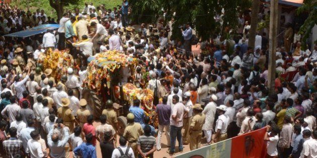 Indian mourners follow the funeral procession for scholar M.M. Kalburgi as he is taken to be buried at Karnataka University in Dharwad on August 31, 2015. Indian scholars on August 31, 2015 condemned the execution-style killing of a leading scholar who had spoken out against idol worship and angered hardline Hindu groups in the run-up to his death. M.M. Kalburgi, an academic and writer from southern Karnataka state, was shot in the forehead after opening the door of his home on August 30 and later died in hospital, police said. AFP PHOTO / STR (Photo credit should read STRDEL/AFP/Getty Images)
