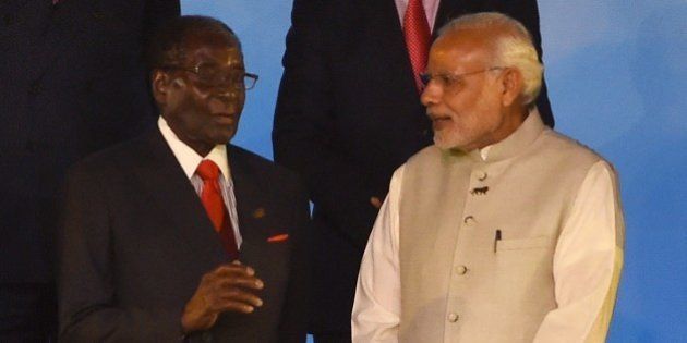 Indian Prime Minister Narendra Modi (R) speaks with Zimbabwe's President Robert Mugabe during the group photograph at the India-Africa Forum Summit in New Delhi on October 29, 2015. Indian Prime Minister Narendra Modi will spell out his vision for the future of his country's economic relations with Africa, as he addresses the major India-Africa Forum Summit in New Delhi. AFP PHOTO / Money SHARMA (Photo credit should read MONEY SHARMA/AFP/Getty Images)