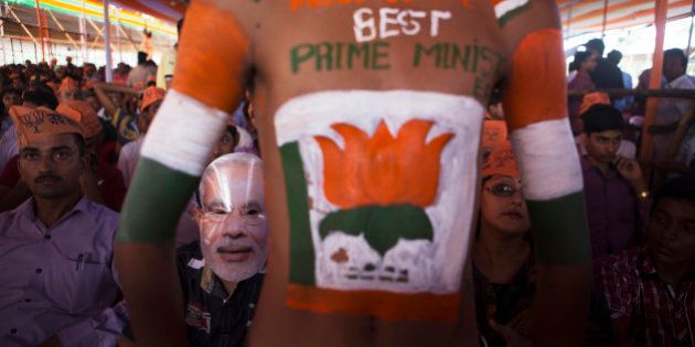 A supporter of the Bharatiya Janata Party (BJP), second left, wears a mask of Indian Prime Minister Narendra Modi during a rally in Muzaffarpur, Bihar, India, on Saturday, July 25, 2015. More than anywhere, Bihar reflects the challenge Prime Minister Narendra Modi faces in overhauling modern India. A vast, landlocked plain bordering the Himalayan nation of Nepal to the north and bisected by the Ganges, India's holiest river, the state is home to about one in 12 Indians. Photographer: Prashanth Vishwanathan/Bloomberg via Getty Images