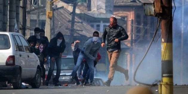 INDIA - 2015/10/30: Kashmiri Muslim protesters throw stones at Indian police during clashes in old Srinagar the summer capital of Indian administered Kashmir. Protesters took to streets in downtown area of Nowhatta shouting slogans in support of Abu Qasim a divisional commander of Lashkar-E-Toiba (a Pakistan based militant outfit) who police claimed had been killed in a gun battle in south Kashmirs Kulgam. Indian Police later fired tear smoke canisters and pellets to disperse any protesters. (Photo by Faisal Khan/Pacific Press/LightRocket via Getty Images)