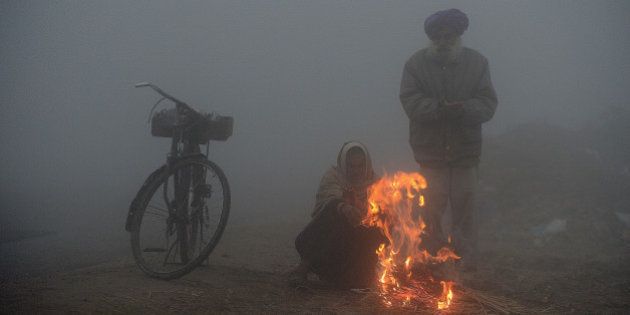 Indian farmers warm themselves around a fire during a dense fog along the India-Pakistan border in Suchit-Garh, 36 kms southwest of Jammu on January 10, 2013. The beheading of an Indian soldier may have sparked a war of words between Delhi and Islamabad but the two nuclear rivals are both determined to prevent it from wrecking a fragile peace process. Two Indian soldiers died after a firefight erupted in disputed Kashmir on Tuesday as a patrol moving in fog discovered Pakistani troops about 500 metres (yards) inside Indian territory, according to the Indian army. AFP PHOTO/Tauseef MUSTAFA (Photo credit should read TAUSEEF MUSTAFA/AFP/Getty Images)