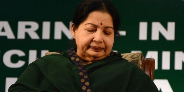 Chief of the All India Anna Dravida Munnetra Kazhagam (AIADMK) party Jayalalithaa Jayaram looks at her watch during her swearing-in ceremony as the chief minister of the southern state of Tamil Nadu in Chennai on May 23, 2015. One of India's most powerful politicians returned May 23, 2015 as chief minister of southern Tamil Nadu state, less than a fortnight after a court acquitted her of corruption. Former film star Jayalalithaa Jayaram was forced to stand down as chief minister of prosperous Tamil Nadu after being found guilty in September 2014 of amassing illegal wealth while in office. AFP PHOTO/STR (Photo credit should read STRDEL/AFP/Getty Images)