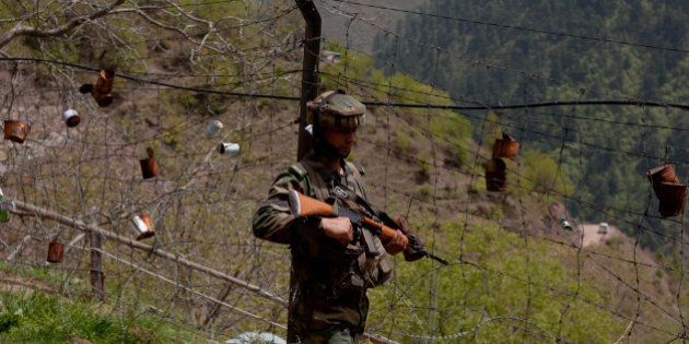 GOHALAN, KASHMIR, INDIA - APRIL 20: An Indian army soldier patrols the fenced area of Line Of Control on April 20, 2015 in Gohalan, 120 Kms (75 miles) north west of Srinagar , the summer capital of Indian administered Kashmir, India. People living along the ceasefire line dividing Kashmir into India and Pakistan-administered portions have continually been at risk due to hostility between the armies of the two nuclear rivals. India on Sunday alledged a ceasefire violation by Pakistan along what New Delhi prefers to call the International Border and Working Boundary by Islamabad, snaking the southern Jammu region of the disputed area. The Indian army in northern Uri district say it has increased its vigil along the Line of Control (LOC), another military line that further divides the region up to the Siachen glaciers. Both Pakistan and India have traded blame over unprovoked shelling which India says is aimed to facilitate the crossover of rebels to their side, a charge Pakistan denies. (Photo by Yawar Nazir/Getty Images)