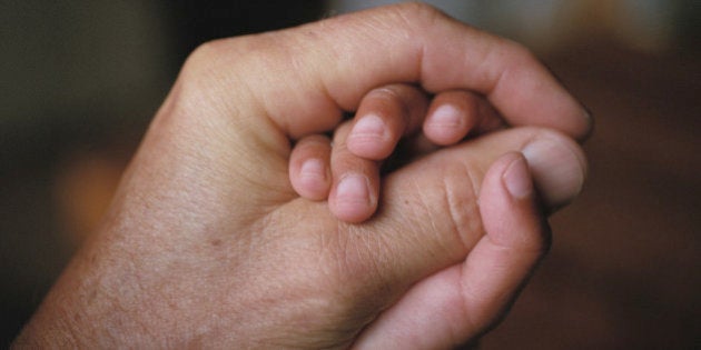 Daughter (2-4) holding father's hands, close up