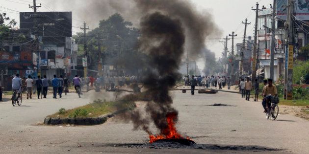 Smoke from tires bellows set on fire by the ethnic Madhesis at Birgunj, a town on the border with India, Nepal, Monday, Nov. 2, 2015. Members of the ethnic Madhesi people have been protesting Nepal's new constitution, saying it divides the Madhesis among a number of states. The Madhesis, who want the creation of a larger state that they would dominate, have imposed a general strike in southern Nepal and blocked the border crossing, resulting in a severe fuel shortage across Nepal. (AP Photo/Jiyalal Sah)