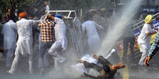 CHANDIGARH, INDIA - OCTOBER 21: Police using the water cannon to spot Simarjit Singh Bains, Independent candidate from Atam Nagar constituency, along with his supporters during the protest against Punjab Chief Minister Parkash Singh Badal outside their residence, on October 21, 2015 in Chandigarh, India. Bains said that the state government is responsible for the incident of sacrilege of Guru Granth Sahib as it fails to arrest the culprits and moreover the two Sikhs were killed in police firing following the orders of the government. (Photo by Gurpreet Singh/Hindustan Times via Getty Images)