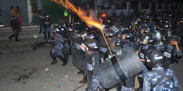 Nepalese roit police fire tear gas at activists from the Brahmin-Chhetri Society outside the Constituent Assembly building, as protesters rally against federalism states in the new constitution, in Kathmandu on May 27, 2012. Nepal's leaders held urgent talks to avoid a political crisis, with just hours remaining before a midnight deadline to agree a new post-war constitution or face the dissolution of parliament.The Constituent Assembly was elected in 2008 after a decade of civil war, with a mandate to write a new national constitution and oversee the peace process that began when the conflict ended in 2006. AFP PHOTO/Prakash MATHEMA (Photo credit should read PRAKASH MATHEMA/AFP/GettyImages)