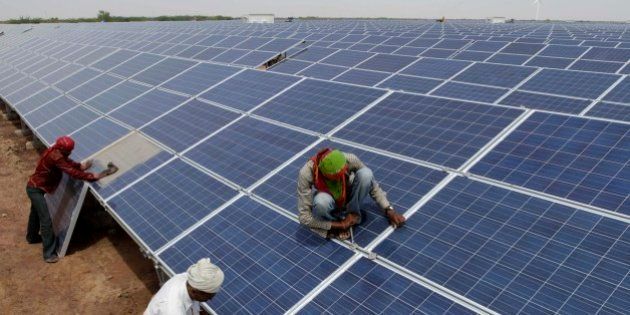 Indian workers install solar panels at the Gujarat Solar Park at Charanka in Patan district, about 250 kilometers (155 miles) from Ahmadabad, India, Saturday, April 14, 2012. Gujarat state Chief Minister Narendra Modi will dedicate the 200 megawatt solar power park, along with other solar projects totaling 600 megawatts of power on April 19. (AP Photo/Ajit Solanki)