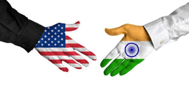 Diplomatic handshake between leaders from the United States and India with flag-painted hands.