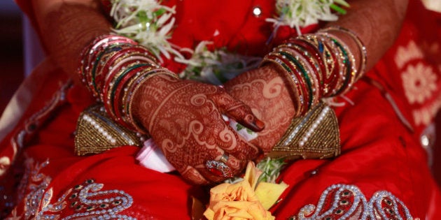 An Indian Muslim bride, her hands decorated with henna, attends a mass wedding organized by a social service organization in Mumbai, India, Sunday, Feb. 15, 2015. Mass weddings in India are organized by social service organizations primarily to help families who cannot afford the high ceremony costs as well as the elaborate dowry that is customary in many communities. (AP Photo/Rafiq Maqbool)