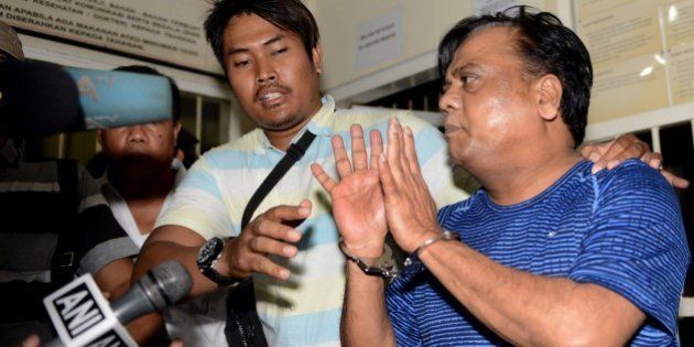 Indian national Rajendra Sadashiv Nikalje, 55, known in India as Chhota Rajan, (R) is held by Indonesian police prior to being escorted from Bali police headquarters to Ngurah Rai Airport during his deportation to India from Denpasar on Bali island on November 5, 2015. The Indian fugitive wanted over a series of murders in his country has been arrested in Indonesia after decades on the run, police said. vAFP PHOTO / SONNY TUMBELAKA (Photo credit should read SONNY TUMBELAKA/AFP/Getty Images)