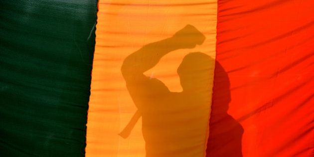 An Indian gay-rights activist gestures behind a flag during a protest against the Supreme Court ruling reinstating a ban on gay sex in Bangalore on December 11, 2013. India's Supreme Court reinstated a colonial-era ban on gay sex on that could see homosexuals jailed for up to ten years in a major setback for rights campaigners in the world's biggest democracy. AFP PHOTO/Manjunath KIRAN (Photo credit should read Manjunath Kiran/AFP/Getty Images)