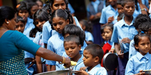 A teacher distributes free mid-day meal to Indian schoolchildren at a government run school on World Food Day in Bangalore, India, Tuesday, Oct. 16, 2012. Blaming flawed methodology and poor data, the United Nations says its 2009 headline-grabbing announcement that 1 billion people in the world were hungry was off-target and that the number is actually more like 870 million. (AP Photo/Aijaz Rahi)
