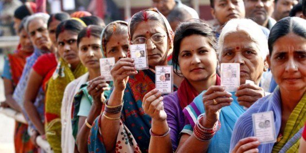 PATNA, INDIA - OCTOBER 28: Voters pose with their ID Cards standing in queue to cast their votes at DAV School, Danapur Cantt, during the third phase of Bihar Assembly Elections on October 28, 2015 in Patna, India. Bihar will hold five-phase elections between October 12 and November 5 to elect the 243-member assembly. Counting of votes will take place on November 8. BJP led NDA and Grand Secular Alliance comprising of RJD, JD (U) and Congress are two main coalitions vying to form the next government in the state. (Photo by Arvind Yadav/ Hindustan Times via Getty Images)